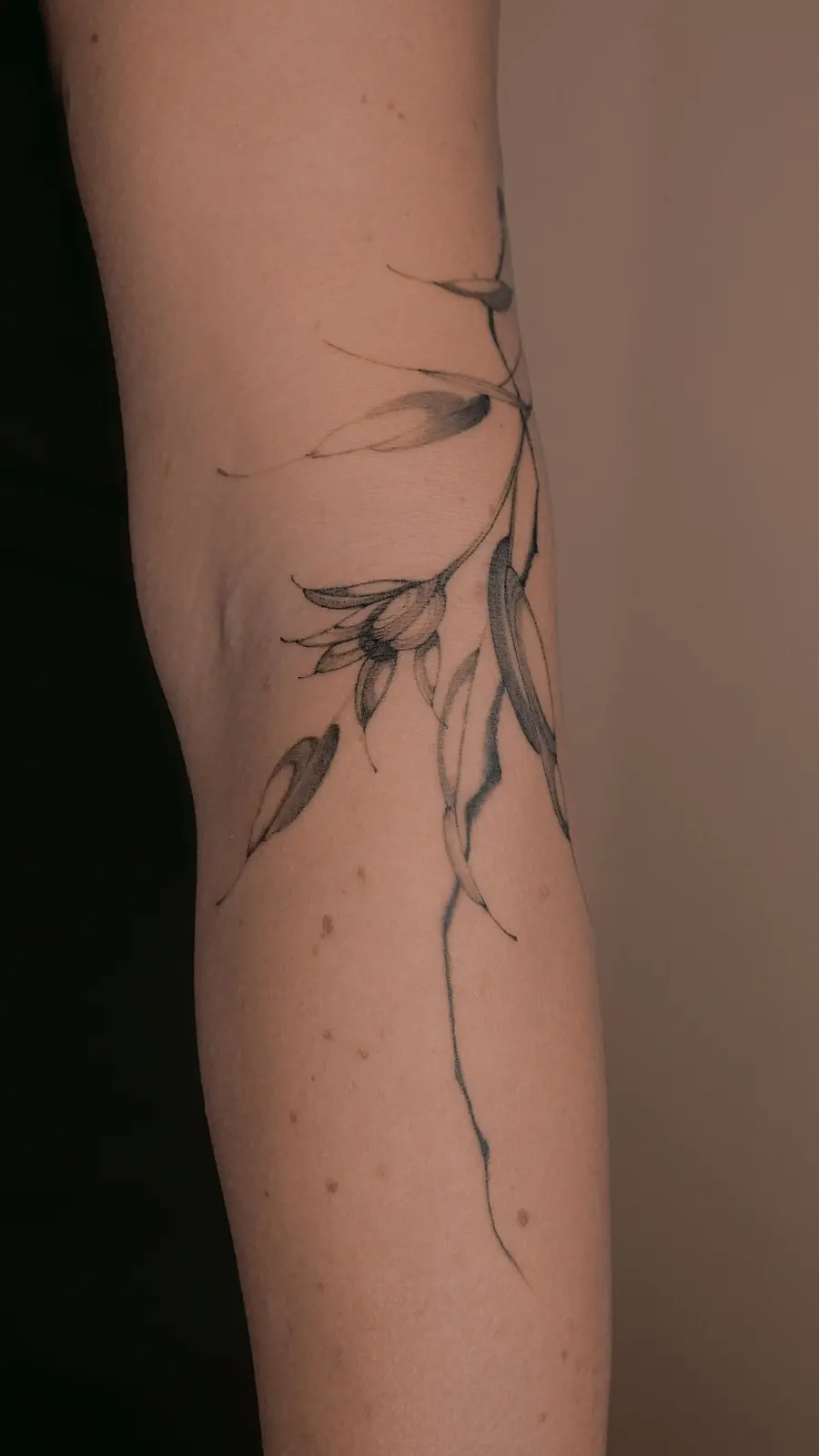 Ethereal fine line flower tattoo on the arm