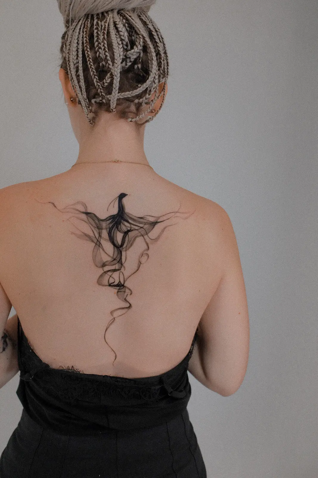 Ethereal flowing black tattoo across the upper back
