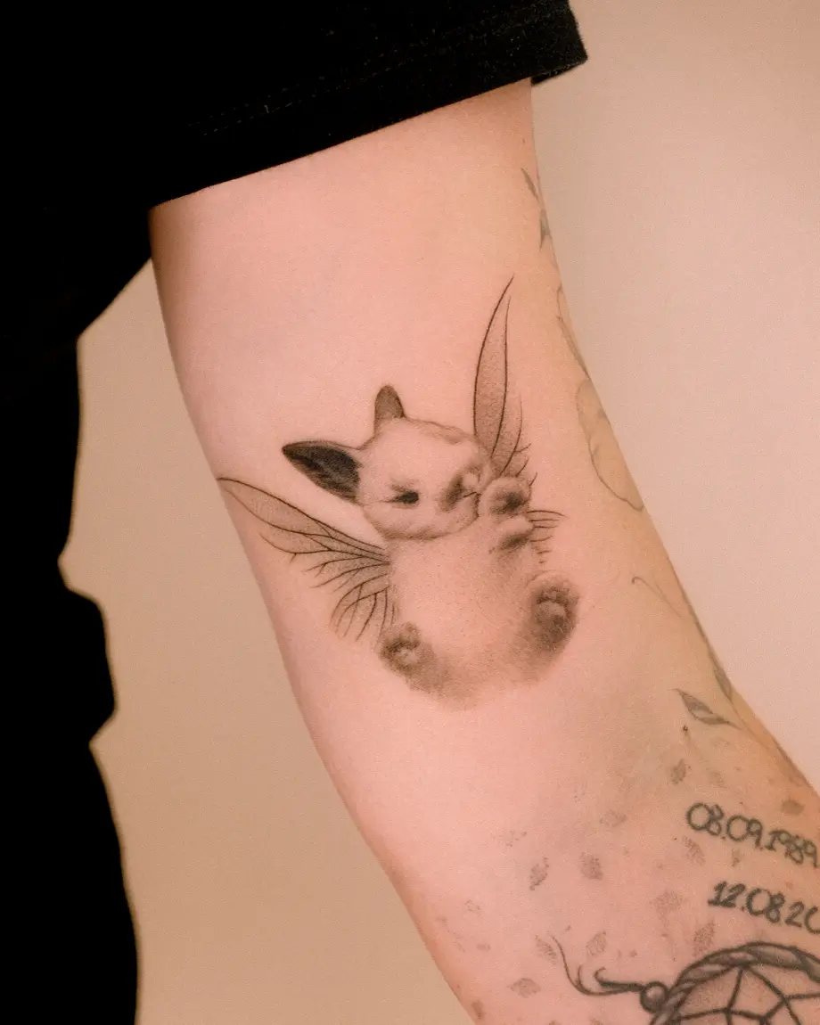 Small microrealistic sleeping fairy cat tattoo