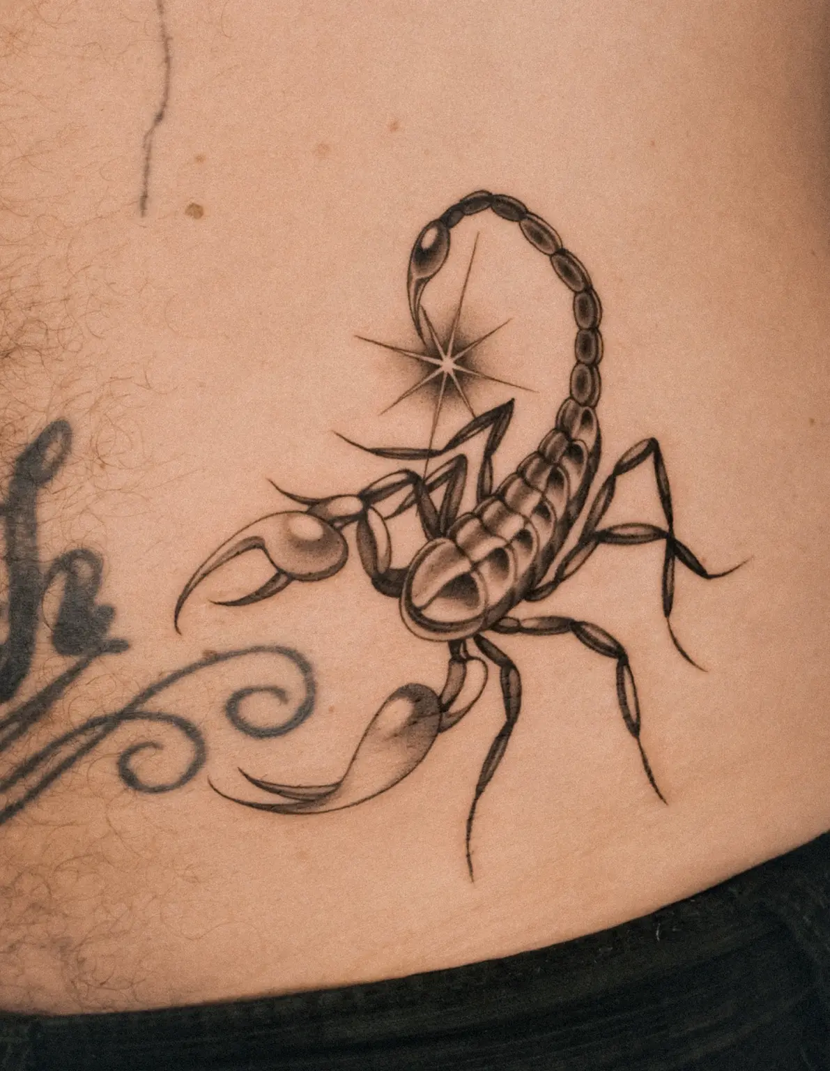Blackwork scorpion tattoo with a star detail