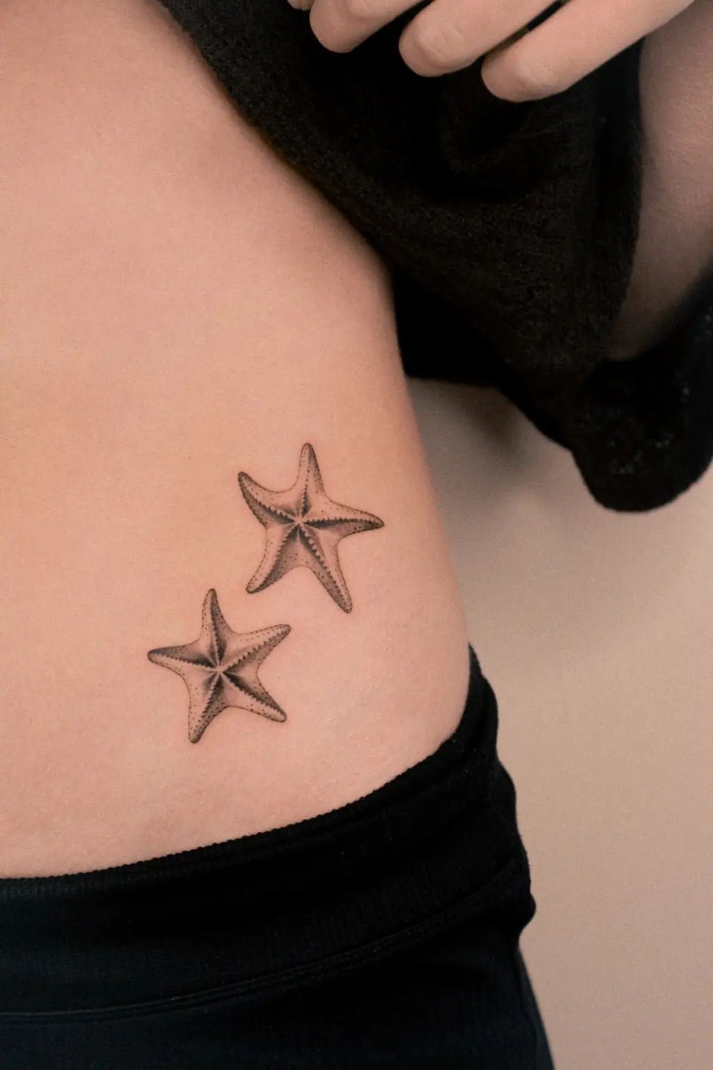 Pair of microrealistic starfish tattoos