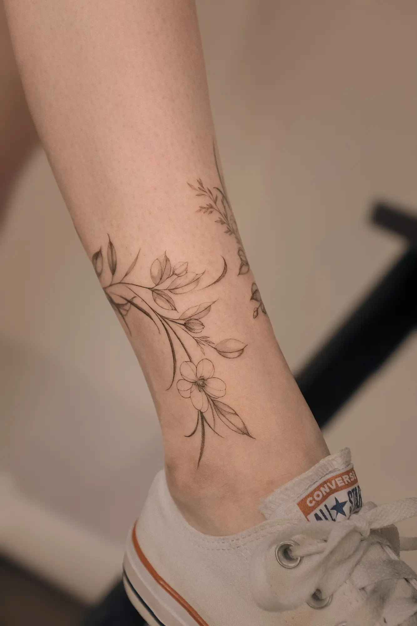 Fine line botanical tattoo wrapping the forearm