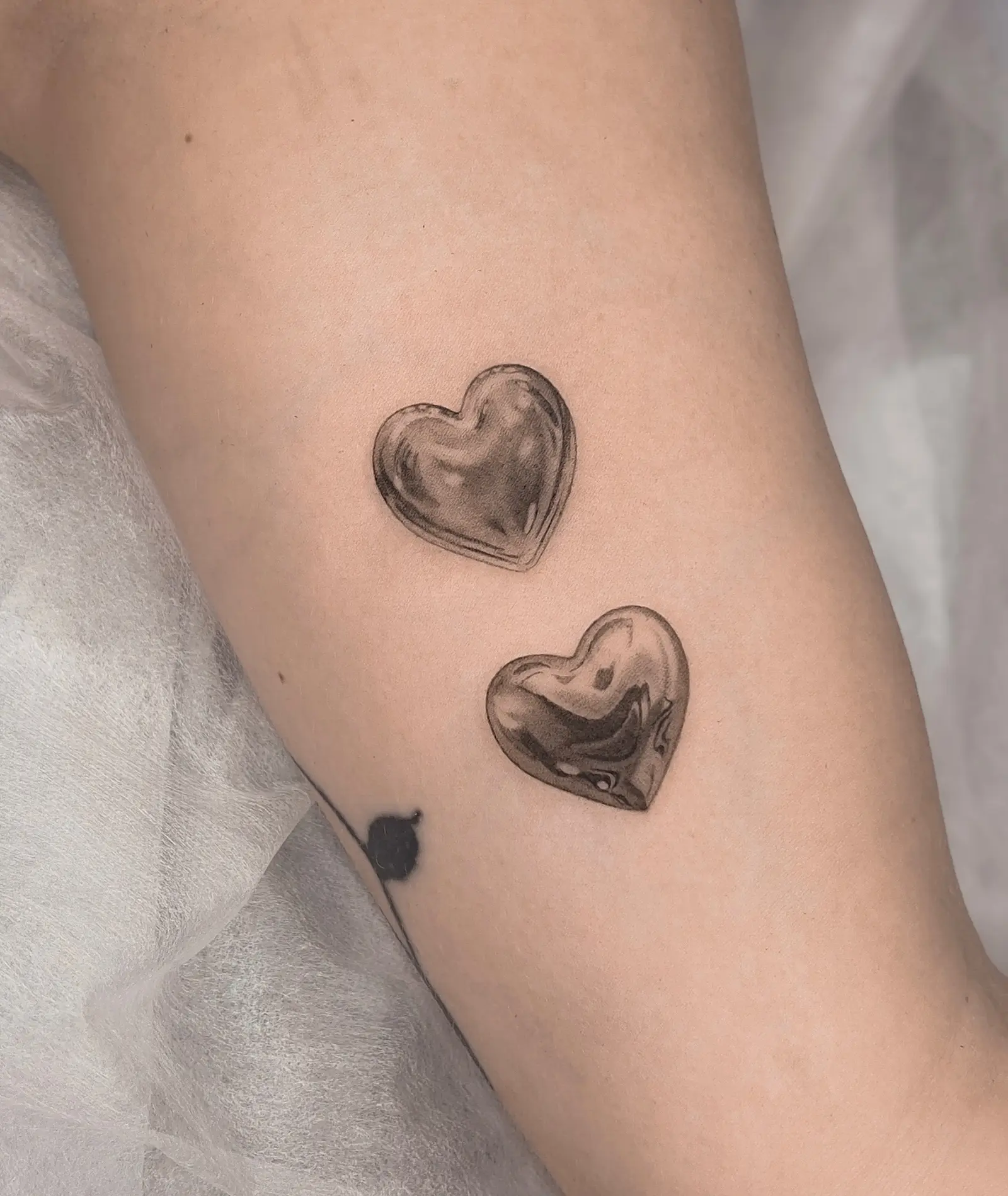 Pair of microrealistic glass heart tattoos