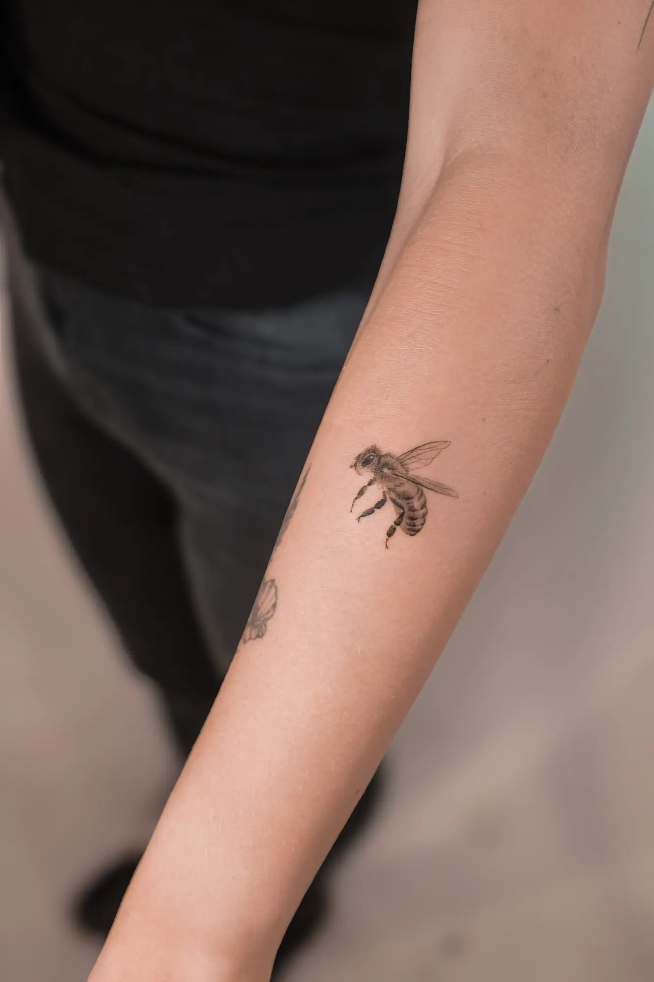 Small microrealistic bee tattoo on the forearm
