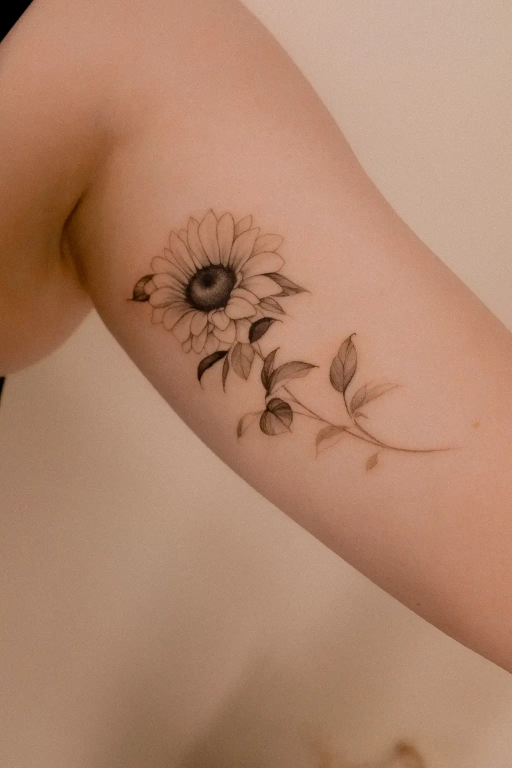 Fine line sunflower tattoo with a small bee